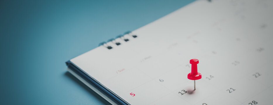Embroidered red pins on a calendar event Planner calendar,clock to set timetable organize schedule,planning for business meeting or travel planning concept.