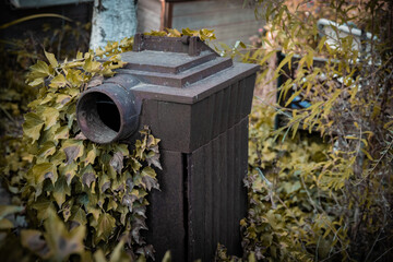 a old tiled stove in an overgrown garden