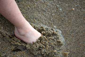 Child's feet in the sand close-up