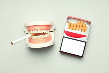 Concept of harm of smoking for teeth on light background
