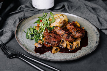 Rare roasted thick juicy beef fillet medallion topped with braised mushrooms and seasoned with fresh herbs