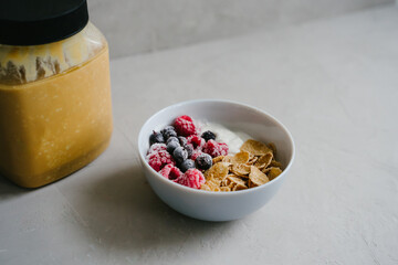 Healthy breakfast with berries, cereals and natural yogurt. Plate with natural yogurt, cereals and berries. Delicious and healthy breakfast. Proper nutrition. Black currant and raspberry frozen. Can o