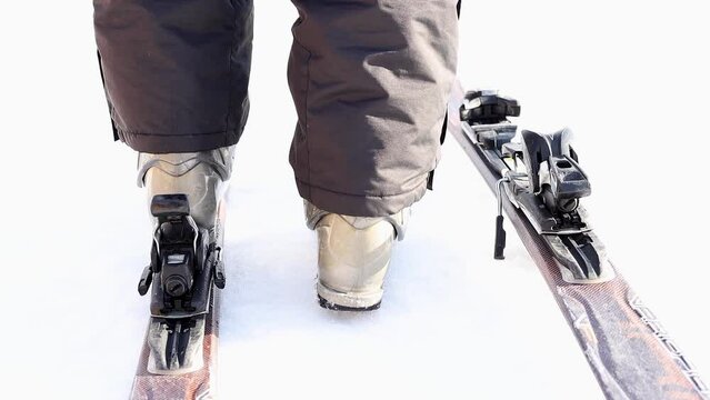 Close-up ski boot stepping in the ski binding in slow motion. Detailed view of ski bindings concept. Winter activity. The concept of rest, hobbies, health