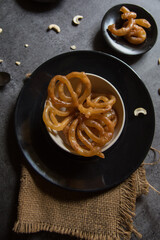 Jalebi or sugar syrup filled rings in a bowl. Close up, selective focus.