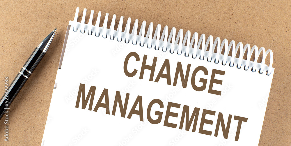 Poster change management text on a notepad with pen, business concept