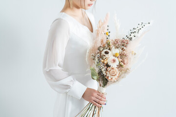 ウェディングドレスを着てブーケを持った花嫁
