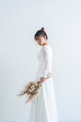 Obraz premium ウェディングドレスを着てブーケを持った花嫁