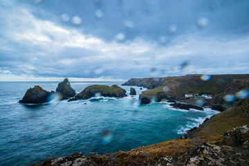 A wet and windy overcast view of the Cornish coast, rain drops on lens.