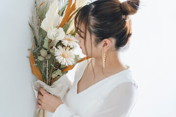 Obraz na płótnie Canvas ウェディングドレスを着てブーケを持った花嫁