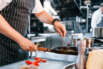 Close up view. Slicing ingredients. Chef is on the kitchen preparing food