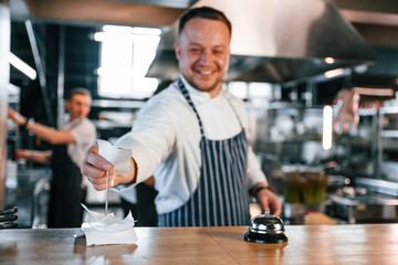 Order is complete. Kitchen workers is together preparing the food