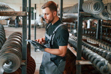 Checking details. Man in uniform is in workstation developing details of agriculture technique