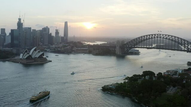 Aerial Panning Left Over Iconic Harbor With Passing Boats At Sunset - Sydney, Australia