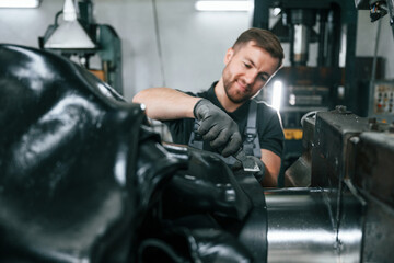 Clean parts. Man in uniform is in workstation developing details of agriculture technique