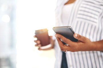 Closeup of professional business woman on her phone working and replying to messages, emails or social media with flare. Black female businessperson holding work and personal cellphone in her office