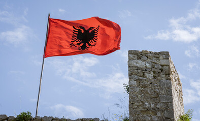 Albania, May 12, 2022 - Albanian flag flies over ruins of Rozafa Castle. - obrazy, fototapety, plakaty