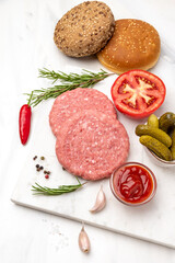 Patty of minced meat for burger. Grey background. Top view.