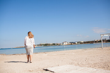 Pretty plus size woman walking in the beach against the sea, enjoy the time with her self, resting and love the nature