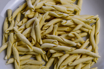 raw strozzapreti, specialties from northern Italy, fresh twisted pasta that cooks very quickly and is suitable for chunky sauces
