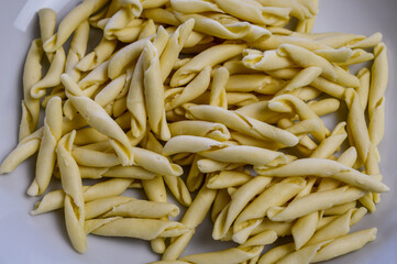 raw strozzapreti, specialties from northern Italy, fresh twisted pasta that cooks very quickly and is suitable for chunky sauces