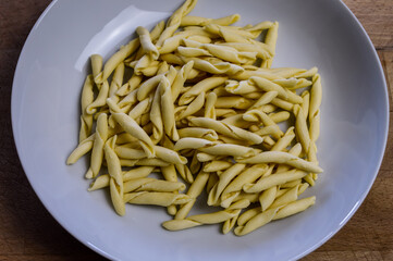 raw strozzapreti, specialties from northern Italy, fresh twisted pasta that cooks very quickly and is suitable for chunky sauces