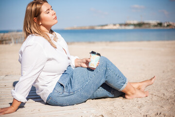 Plus size woman resting in the beach against the sea