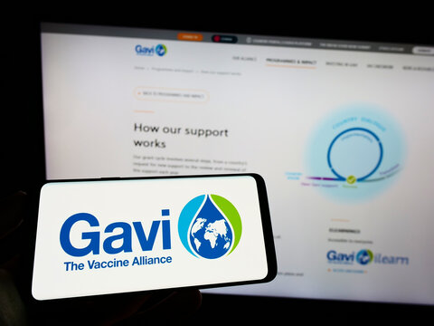 Stuttgart, Germany - 07-31-2022: Person holding cellphone with logo of health partnership Gavi, the Vaccine Alliance on screen in front of webpage. Focus on phone display.
