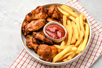 Spicy chicken wings with potatoes fries and ketchup