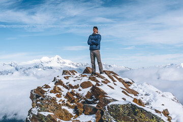 man on a snow covered peak in a mountain landscape