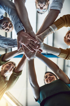 Winning, celebrating and successful business people stack hands in the office for team building. Group of employees in agreement on unity, help and support together at the workplace