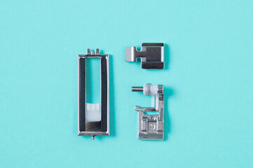 Metal paws for  sewing machine. Turquoise background.