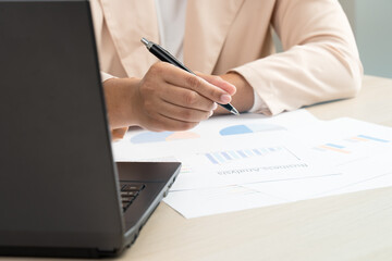 Business woman working for budget or report graph document paper on desk