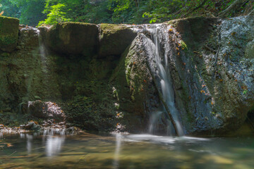 Fototapeta na wymiar Cascade waterfall in the riverside