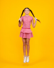 Amazed teenager. Excited teen girl. Full length funny teenager kid jump enjoy rejoice win isolated on yellow background. Small child girl in summer dress jumping.