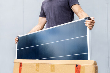 Person taking a new solar panel out of the box