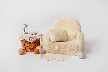 Shoot set up with sofa, table and balls of thread for newborn on white background. Photo zone for a photo session of newborns. Decoration is ready for newborn photo shoot and baby photography