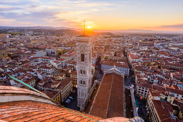 The bell tower Giotto's Campanile with the rooftop of Santa Maria del Fiore Duomo in Florence...