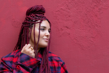 Portrait of young woman with red dreadlocks wearing a red checkered shirt