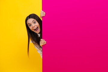 Teenage girl holds a blank for notification informing. Advertisement and sale. Markets and shops sales concept, blank board for copy space. Excited face, cheerful emotions of teenager girl.