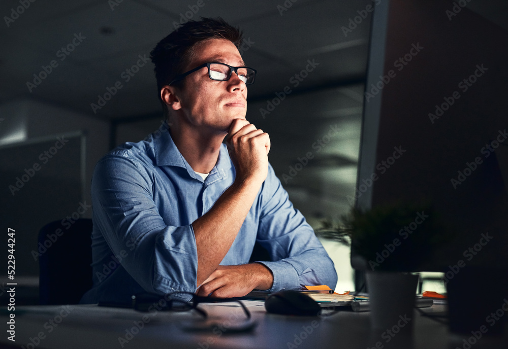 Leinwandbilder businessman thinking of ideas in front of a computer while working late in an office at night. hard 