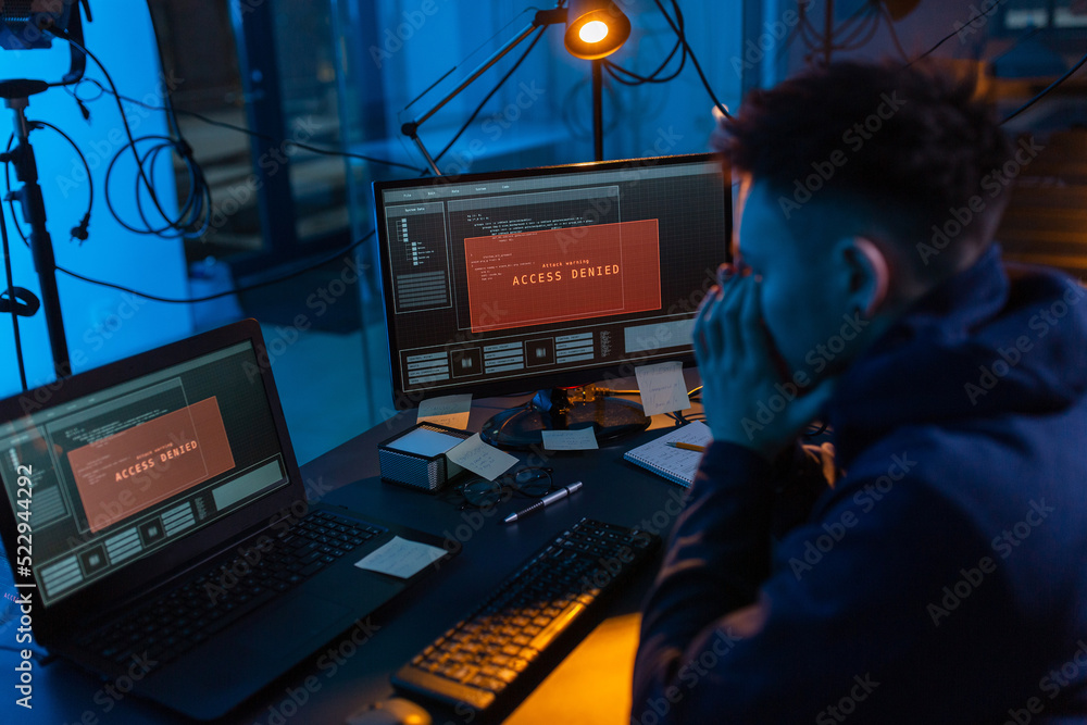 Poster cybercrime, hacking and technology concept - male hacker in dark room using computer virus program f