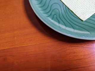 Close up of blue plate over the wooden table on the restaurant.  The photo perfect for food promotion for, pamphlet of restaurant and drink advertising.