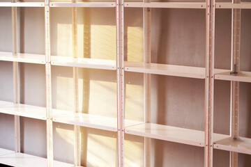 Stockroom, empty warehouse with shelves. White slats and cells without things and without goods