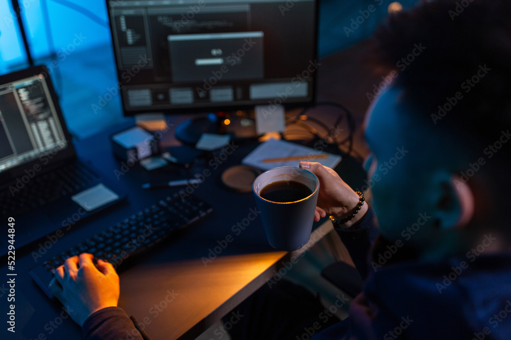 Poster cybercrime, hacking and technology concept - close up of male hacker in dark room drinking coffee an