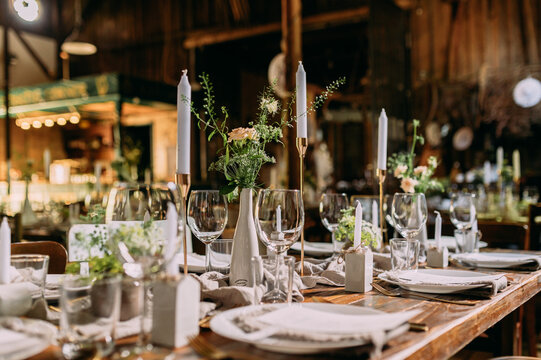 Festlich gedeckter Tisch auf einer Hochzeit in einer Scheune Landhochzeit