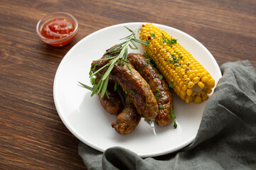Close up of griiled food sweet corn on cob and beef sausages