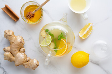 Top view of winter herbs spica and fruit tea in glass teapot