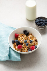 Morning granola in white bowl berry and vegan milk