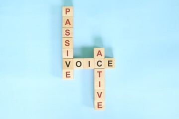 Active and passive voice topic in English grammar teaching. Wooden block crossword puzzle flat lay...