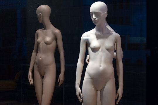 Naked female mannequins in the shop window. Fashion clothing woman mannequin in the store.